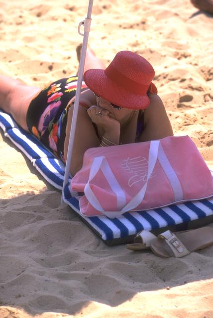 Mujer obesa tumbada en la playa.